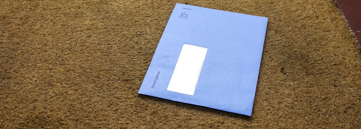 Blauwe envelop van de Nederlandse belastingdienst op de deurmat, Prinsjesdag, Belastingen, Miljoenennota