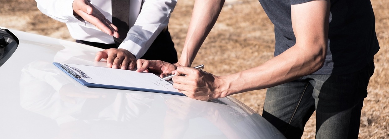 Verzekeringsagent en de eigenaar van de auto tekenen de overeenkomst voor een schadeclaim