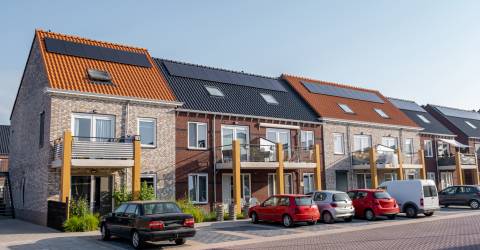 Nieuw gebouwde huizen met zonnepanelen op het dak met op de achtergrond een mooie blauwe lucht